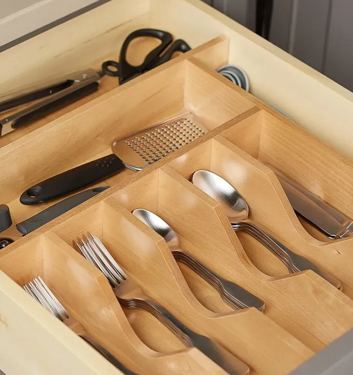 Wood organizer dividing cutlery and utensils in a cabinet drawer